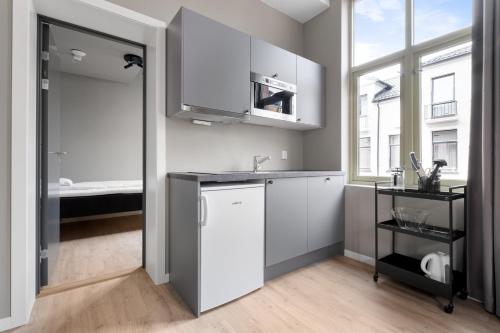 a kitchen with white cabinets and a sink at Forenom Serviced Apartments Drammen in Drammen
