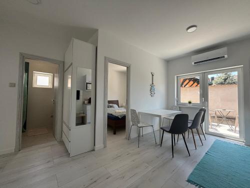 a living room with a table and chairs and a dining room at SL Apartman Siófok in Siófok