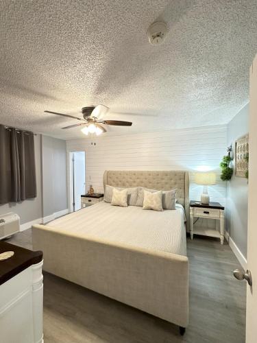a bedroom with a large bed with a ceiling fan at SeaBliss, oceanfront 1st floor cozy condo in Daytona Beach