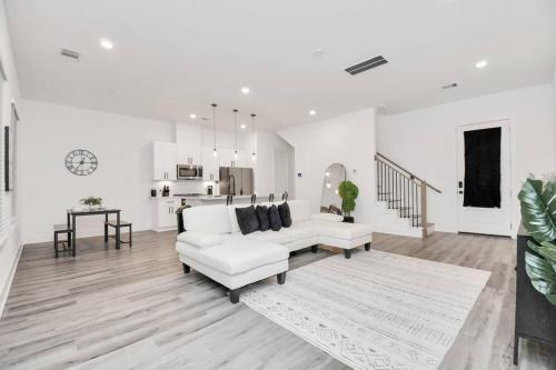 a white living room with a white couch and a table at Stylish 4 Beds - Min to Downtown With Backyard in Houston