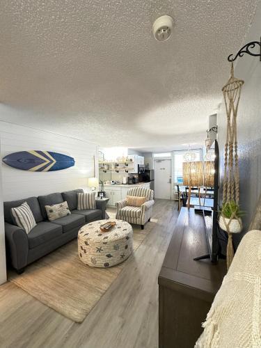 a living room with a couch and a table at SeaBliss, oceanfront 1st floor cozy condo in Daytona Beach