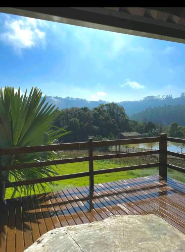a view from the deck of a house with a fence at Chalé encanto do sol in Laurentino