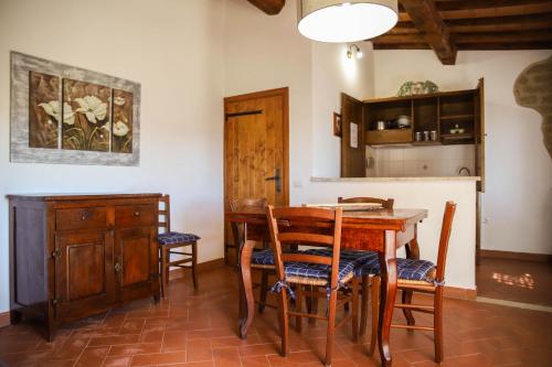 een eetkamer met een houten tafel en stoelen bij Country House Poggio Aione in Catabbio