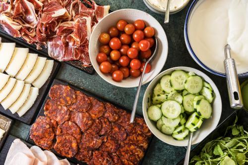una mesa cubierta con platos de carne y hortalizas en Live it Madrid Gran Vía, en Madrid