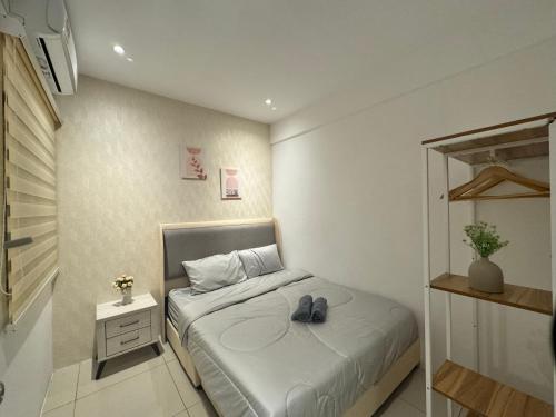 un dormitorio pequeño con una cama con zapatos. en Ipoh Waterpark Manhattan Premium Suites by IWH Suites en Ipoh