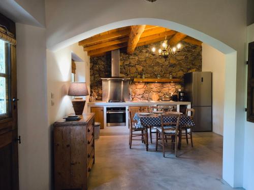 a kitchen with a table and chairs and a refrigerator at Les Bergeries de Piazzagina in Piediquarciu