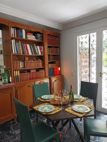 une salle à manger avec une table et des chaises vertes dans l'établissement Vincennes, pour 8, avec grand jardin, à Vincennes
