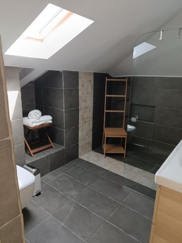 a bathroom with a sloped ceiling with a glass shower at Airport Loft , paiania in Paianía