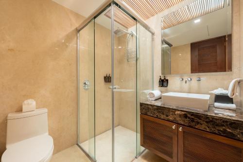 a bathroom with a shower and a toilet and a sink at Capitalia Tres Mares Beach Residences & Marina in Puerto Vallarta
