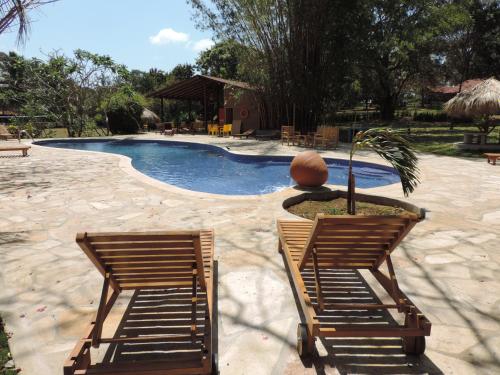 2 sillas sentadas frente a una piscina en Hotel Amigo Nicaragua en Nindirí