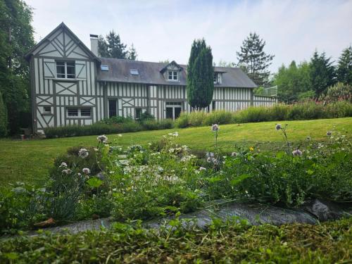 une maison ancienne avec un jardin en face dans l'établissement Authentique Maison Normande avec Piscine, à Tourgéville