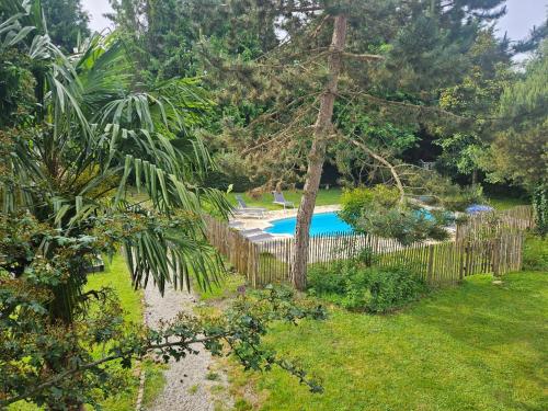 une clôture autour d'une piscine dans un jardin dans l'établissement Authentique Maison Normande avec Piscine, à Tourgéville