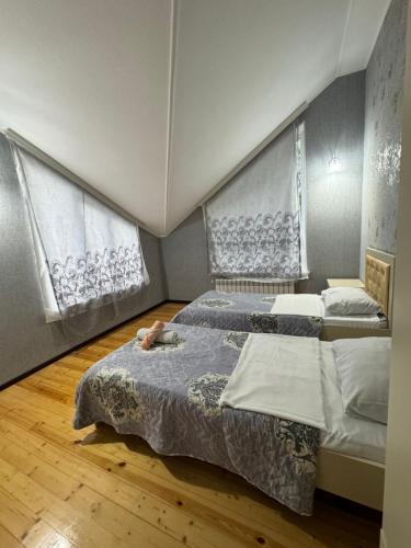 a bedroom with two beds and two windows at Peak Paradise Gabala Villa in Gabala