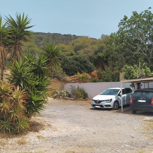 two cars parked in a driveway next to a house at BY THE SEA ROOMS, AVLAKI in Porto Rafti