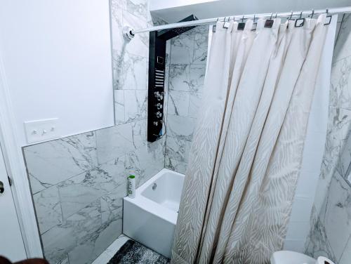 y baño con cortina de ducha y lavamanos. en Luxurious 3 Bedroom Apt with a beautiful balcony, en Washington