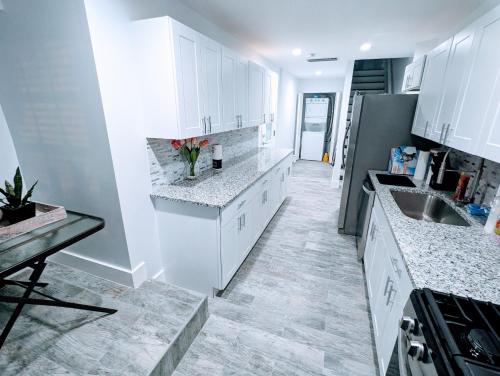 a kitchen with white cabinets and a vase of flowers at Luxurious 3 Bedroom Apt with a beautiful balcony in Washington, D.C.