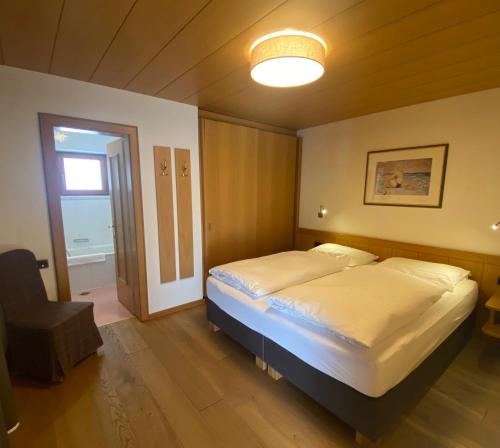 ein Schlafzimmer mit einem großen Bett und einer Lampe in der Unterkunft Residence Cesa Callegari in Wolkenstein in Gröden
