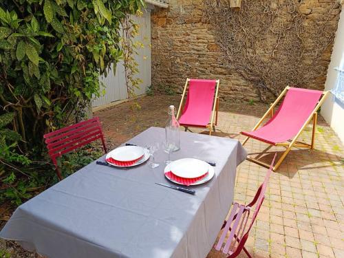 une table avec deux chaises roses et une table avec des verres dans l'établissement Chez Louisette Centre ville et plages à pied!, à Concarneau