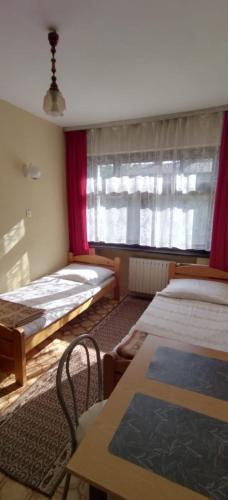 a bedroom with two twin beds and a window at Noclegi Beskidzkie in Korbielów