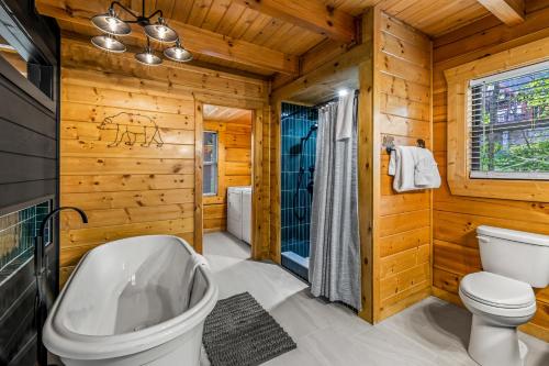 a log cabin bathroom with a toilet and a sink at Dawns View in Sevierville