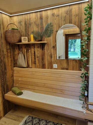 bagno con parete in legno e specchio di Mīļpirtiņa Guguči a Straupe