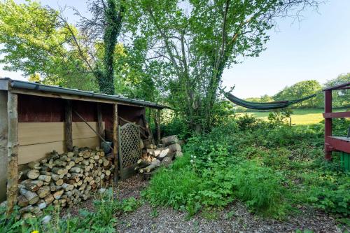 a pile of fire wood next to a shed at Ferien Tinyhaus im Tale in Ascheffel