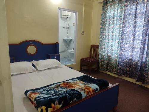 a bedroom with a bed with a blue headboard and curtains at Dal Point view in Srinagar