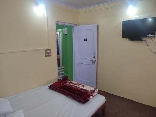 een kleine kamer met een bed en een televisie bij Dal Point view in Srinagar