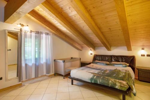 sypialnia z łóżkiem i drewnianym sufitem w obiekcie Casa Michod - Nonno Marcel w mieście Châtillon