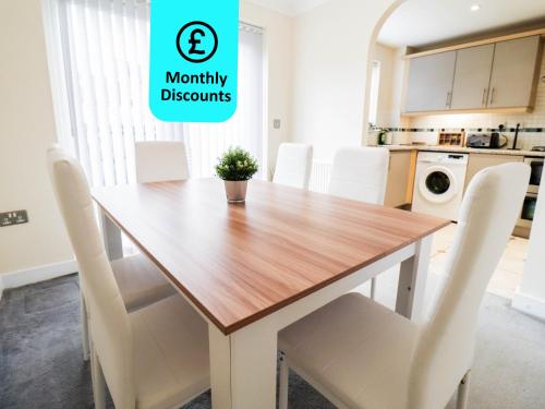 una sala da pranzo con tavolo in legno e sedie bianche di 3BR House with Parking near Iron Pier Thames River a Woolwich