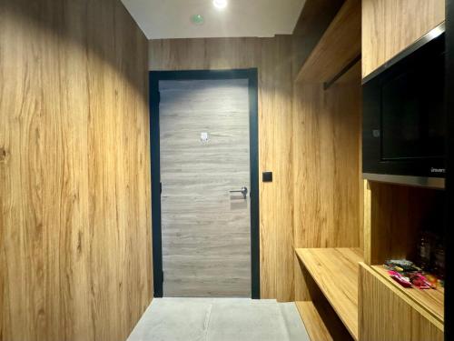 Una puerta de madera en una habitación con TV en Boutique Palacio, en Alicante