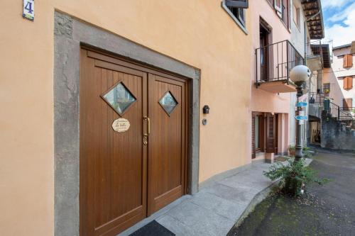 a large wooden door on a building with a street at Le Volte - Lago D'Iseo in Pisogne