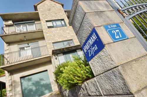 a building with a blue street sign in front of it at Apartments Dinko Zifra in Tivat