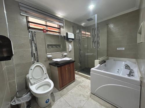 La salle de bains est pourvue de toilettes, d'une baignoire et d'un lavabo. dans l'établissement Tropicals Resort, 