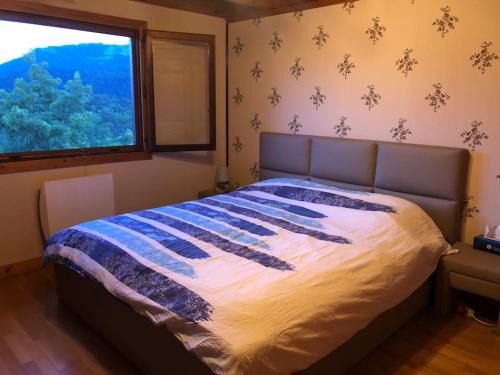 une chambre avec un grand lit avec une fenêtre dans l'établissement Grand chalet - Mieussy, à Mieussy