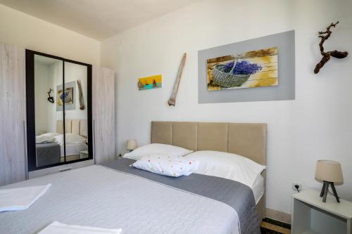 una camera da letto con un letto e uno specchio di Juric 32 - Boutique Apartments a Hvar