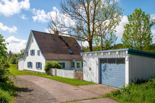 a white house and a garage next to a house at Ferienhaus Allgäuperle in Altusried