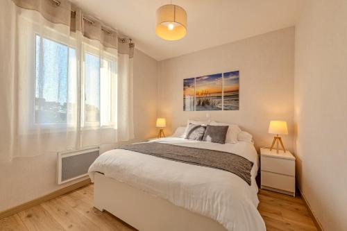um quarto com uma cama grande e 2 janelas em La Maison Des Gardiens De L'océan - em Plougonvelin