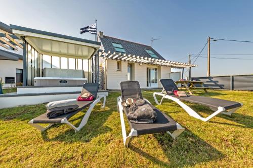 three lounge chairs on the grass in front of a house at La Maison Des Gardiens De L'océan - in Plougonvelin
