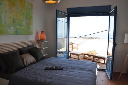 a bedroom with a blue bed and a balcony at Villa Kimmi Natursteinhaus in Ierápetra