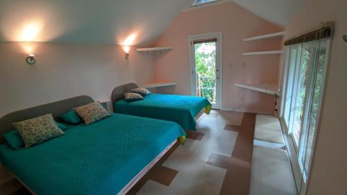 a small room with two beds and a window at La Esperanza Lodge and Reserve in Jardin