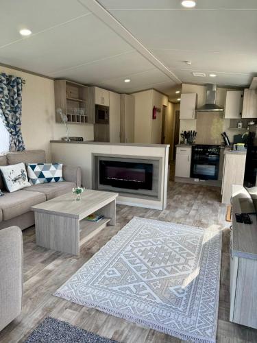 a living room with a couch and a table and a kitchen at Stylish 3-bed Mobile Home on St Helen's Coastal Resort, Isle of Wight in Saint Helens