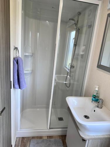 a bathroom with a shower and a sink at Stylish 3-bed Mobile Home on St Helen's Coastal Resort, Isle of Wight in Saint Helens