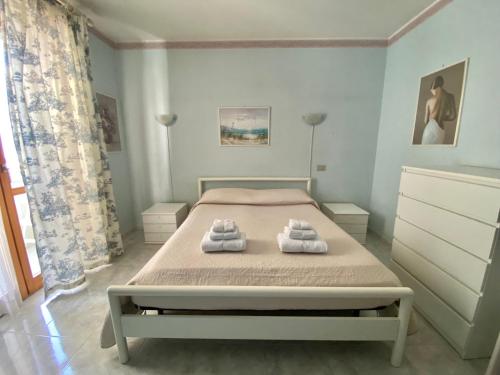 una camera da letto con un letto con asciugamani sopra di La Tana Alghero ad Alghero