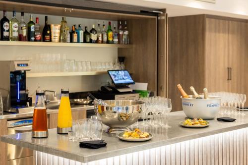 a kitchen counter with plates of food and wine glasses at Staybridge Suites - Cannes Centre by IHG in Cannes