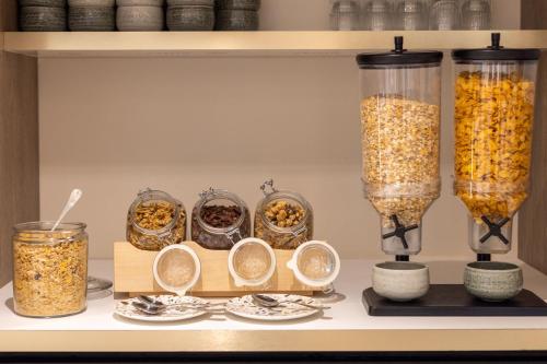a shelf with bowls of food and two vases of popcorn at Staybridge Suites - Cannes Centre by IHG in Cannes