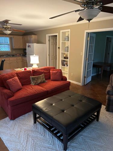 a living room with a red couch and a coffee table at Pool House in Clarksdale