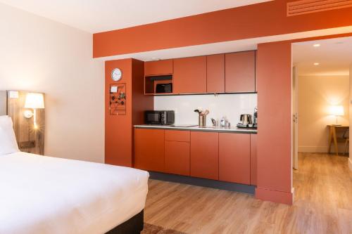 a hotel room with a bed and a kitchen at Staybridge Suites - Cannes Centre by IHG in Cannes