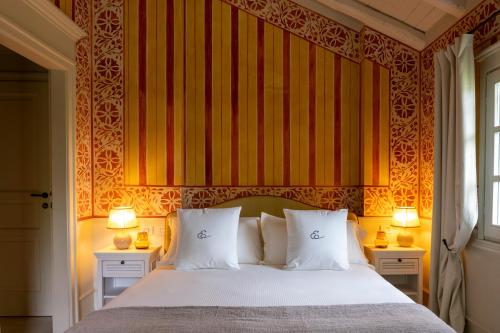 a bedroom with a bed with two lamps on two tables at Elizabeth Country House, a Member of Design Hotels in Minerbio