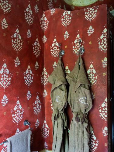 apron hanging on a wall with a red background at Elizabeth Country House, a Member of Design Hotels in Minerbio